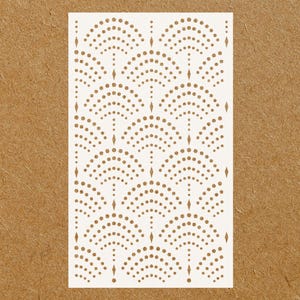 May include: White stencil with a repeating pattern of small circles arranged in a semi-circular shape. The circles are arranged in rows to create a geometric design.