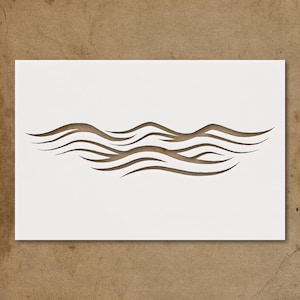 May include: A white rectangular stencil featuring a brown, stylized wave design. The wave pattern consists of several curved lines, creating a flowing, water-like appearance. The stencil is set against a neutral background.