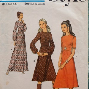 May include: A vintage sewing pattern for three different dresses. The pattern is for a young junior or teen size 13/14 with a bust measurement of 33 1/2 inches. The dresses are shown in brown, red, and white with geometric patterns.