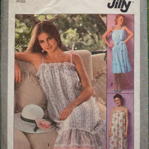 May include: Simplicity sewing pattern 8512 Jiffy for a petite size 6-8 miss dress. The pattern shows three variations of a sleeveless dress with a ruffled hem. The first variation is a floral print dress with a white background. The second variation is a light blue dress with a white background. The third variation is a floral print dress with a white background.