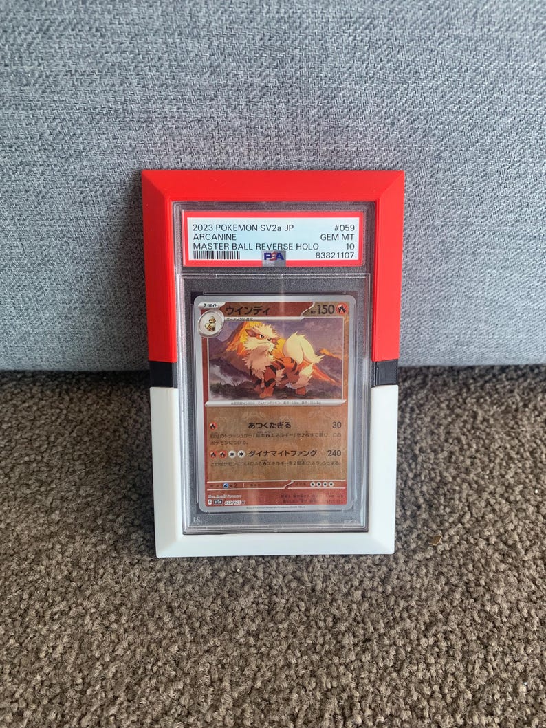 May include: A framed Pok&eacute;mon trading card featuring Arcanine. The card is encased in a clear plastic holder within a red, white, and black frame. The card's text includes "2023 Pokemon SV2a JP" and "Master Ball Reverse Holo."