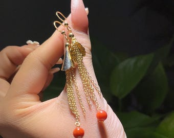 Gouden oorbellen met kwastje en rood koraal: statement sieraden voor glamoureuze avonden en culturele evenementen