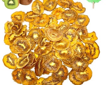 May include: A collection of dried kiwi fruit slices, golden-brown in colour, next to fresh kiwis. A sign reading "100% ORGANIC" is also present. The dried fruit has a textured appearance, and the fresh kiwis are green and brown.