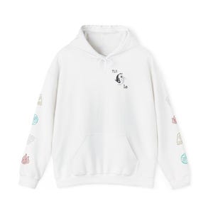 May include: White hoodie with a front pocket and drawstring hood. The front features a black and white yin-yang symbol with the text "TUI la". The sleeves have colourful symbols. A casual, comfortable garment.