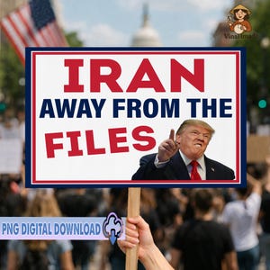 May include: A protest sign with the words "IRAN AWAY FROM THE FILES" in red and white lettering, with a picture of Donald Trump pointing. The sign is held up by a person in a crowd, with an American flag in the background.