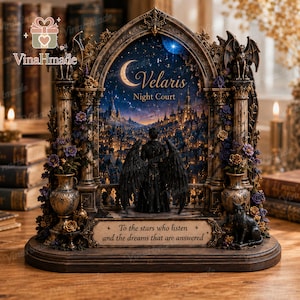 May include: A decorative arched display featuring a winged figure standing before a night cityscape. The scene includes the text "Velaris Night Court" and "To the stars who listen and the dreams that are answered," with ornate columns, gargoyles, and floral accents.