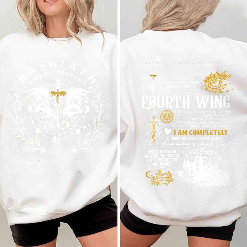 May include: White sweatshirt with gold and white graphic designs. The front features text that says "BASGIATH WAR COLLEGE" and a sword design. The back has "FOURTH WING" and other text with a sword and eye design.