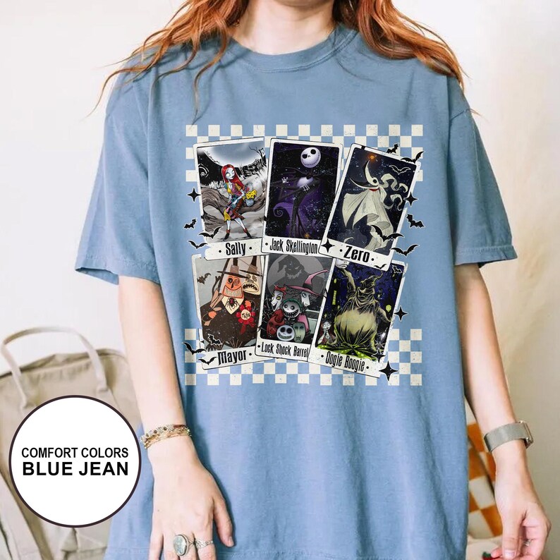May include: Blue jean Comfort Colors t-shirt featuring a graphic of characters from The Nightmare Before Christmas. The design includes images of Sally, Jack Skellington, Zero, Mayor, Lock, Shock, Barrel, and Oogie Boogie.