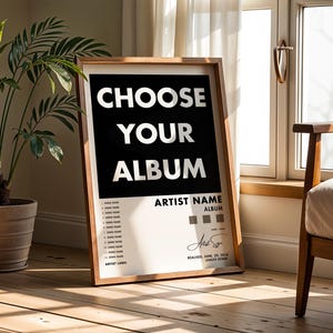 Könnte beinhalten: Ein gerahmtes Poster mit dem Text "CHOOSE YOUR ALBUM" in Weiß auf schwarzem Hintergrund. Das Poster enthält Platz für Künstler- und Albumdetails, Songtitel und eine Unterschrift. Der Rahmen ist hellbraun.