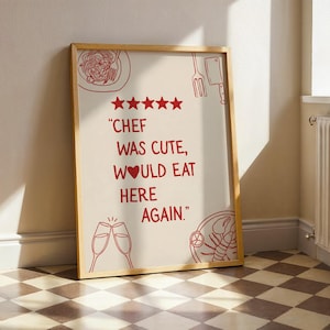 Peut inclure: Une affiche encadrée avec un fond crème et des dessins au trait rouges d'aliments et de boissons. Le texte dit "Chef was cute, would eat here again." L'affiche est appuyée contre un mur sur un sol à carreaux.