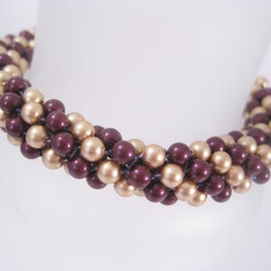 May include: A brown and gold beaded necklace with a twisted design. The necklace is made of small, round beads that are strung together in a repeating pattern.