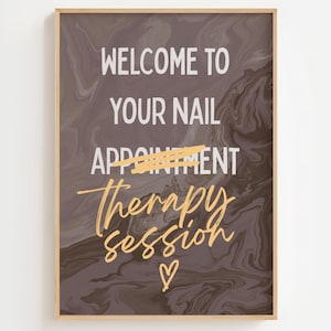 May include: A framed print with a marbled background in shades of brown and gray. The text reads "WELCOME TO YOUR NAIL THERAPY SESSION" in white and gold lettering. A gold heart is at the bottom.