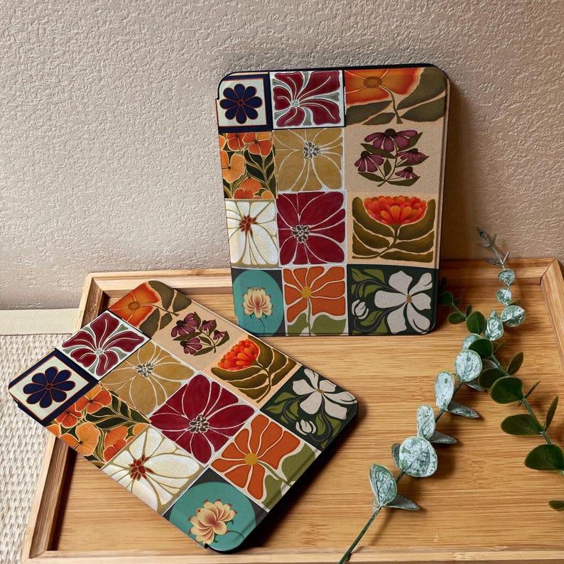 Puede incluir: Dos estuches con un dise&ntilde;o floral de patchwork, uno rectangular y otro cuadrado, est&aacute;n colocados sobre una bandeja de madera. Los estuches presentan una variedad de flores en rojo, naranja, amarillo y blanco, sobre un fondo beige. El estuche cuadrado est&aacute; inclinado hacia el espectador.