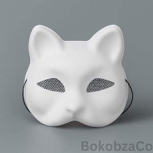 Puede incluir: Una máscara blanca con forma de gato con cubiertas oculares de malla negra y cuerdas negras. La máscara tiene orejas puntiagudas y una forma suave y redondeada. El texto "BokobzaCo" es visible en la esquina inferior derecha.