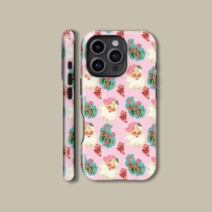 May include: Pink phone case featuring a repeating pattern of Santa Claus faces, candy canes, and holly sprigs. The Santa Claus has a white beard and a pink hat. The candy canes are red and white. The holly sprigs are green with red berries.