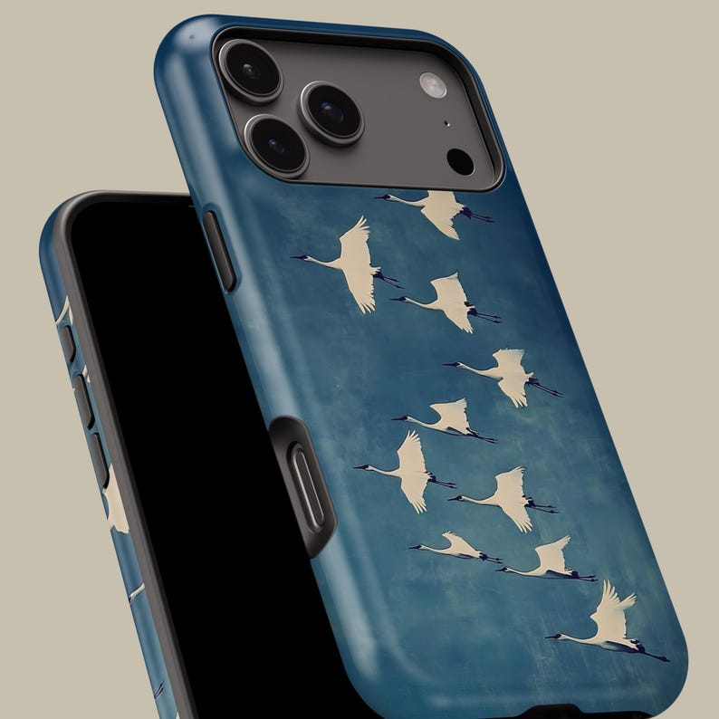 May include: A smartphone case with a blue background featuring a flock of white cranes in flight. The case is made of a durable material and has a sleek design. The case is designed to protect the phone from scratches and damage.