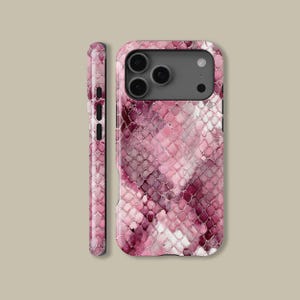 Puede incluir: Una funda de teléfono rosa y blanca con estampado de piel de serpiente. La funda tiene un acabado brillante y presenta un recorte para una cámara de tres lentes. El lateral de la funda también es visible, mostrando el mismo patrón de piel de serpiente. La funda está diseñada para proteger el teléfono.