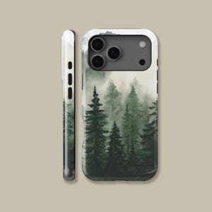 May include: A phone case featuring a watercolor painting of a misty forest with tall green trees. The case has a white border and a side view showing the phone's buttons. The design wraps around the edges.