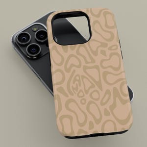 May include: A beige phone case with a repeating abstract pattern in a lighter shade of beige. The case is on top of a black smartphone with multiple camera lenses.