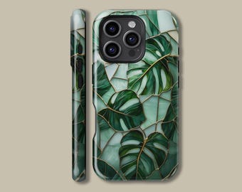 May include: A smartphone case featuring a green and gold monstera leaf design. The case has a mosaic-like pattern with dark green leaves and gold outlines. The case is shown from the front and side, showcasing the design and the phone's camera.
