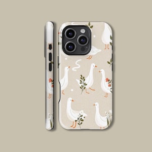May include: A beige phone case with a repeating pattern of white geese, orange beaks and feet, and green sprigs and red flowers. The case has a matte finish and a three-camera lens cutout.