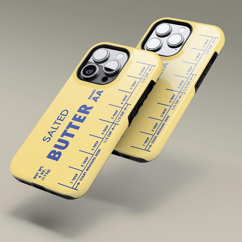 May include: A yellow iPhone case with a butter stick label design. The label reads "Salted Butter Grade AA" and has a measurement guide in tablespoons and cups. The case is designed to look like a vintage butter stick.