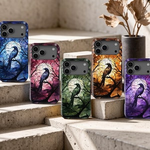 May include: Five smartphone cases featuring a stained-glass style design of a crow perched on a tree branch against a full moon. The cases are displayed in blue, pink, green, orange, and purple colour variations, each with a camera cutout.