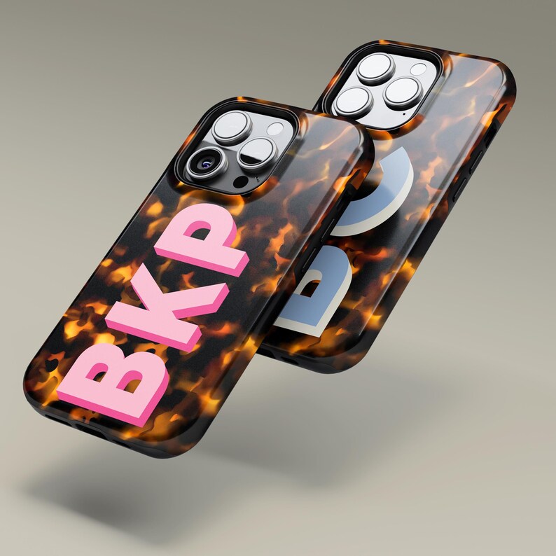 Puede incluir: Dos fundas para tel&eacute;fono con un patr&oacute;n de caparaz&oacute;n de tortuga. Una funda tiene las letras "BKP" en rosa.