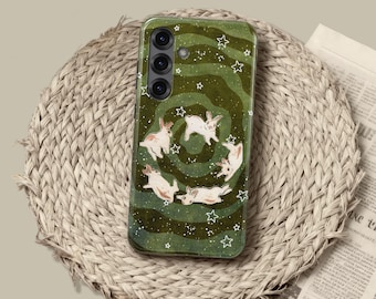 May include: A rectangular smartphone case featuring a dark green background with a swirling, wavy pattern. The design includes multiple white illustrations of small rabbits in various poses, accented by scattered white stars and tiny dots.