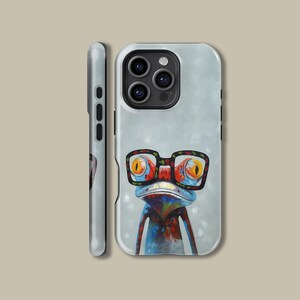 Puede incluir: Una funda de teléfono con una rana colorida que lleva gafas. La rana tiene colores rojo, naranja, azul y verde. La funda es blanca con un fondo azul claro.
