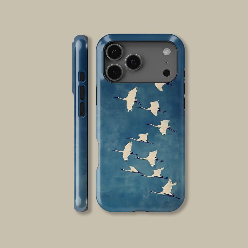 May include: A blue phone case featuring a flock of white cranes in flight against a textured blue background. The case has a glossy finish and a dark blue side profile. The design is a stylized illustration.