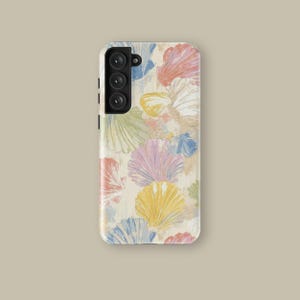 Puede incluir: Una funda de teléfono con un patrón repetido de conchas marinas coloridas en tonos rosa, amarillo, azul y verde. El diseño está sobre un fondo color crema. La funda tiene recortes para la cámara y los botones.