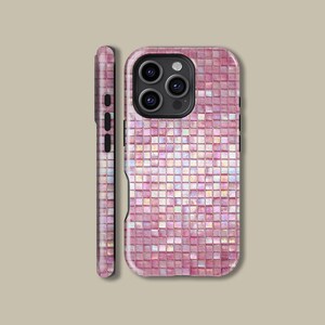 Pode incluir: Uma capa de telefone rosa com um design de mosaico. A capa tem um acabamento brilhante e apresenta um recorte para a câmera. A lateral da capa também é visível, mostrando os botões de volume e energia.