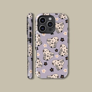 Op de afbeelding: Een lavendelkleurige telefoonhoes met een herhalend patroon van spookillustraties en bloemaccenten in zwart en crème. De hoes heeft ook een zijaanzicht met hetzelfde ontwerp. De hoes is ontworpen voor een smartphone.