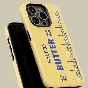 May include: A yellow phone case with a stick of butter design. The case has a blue label that reads "SALTED BUTTER AA" and includes a measurement guide in tablespoons and cups. The case is designed for an iPhone.