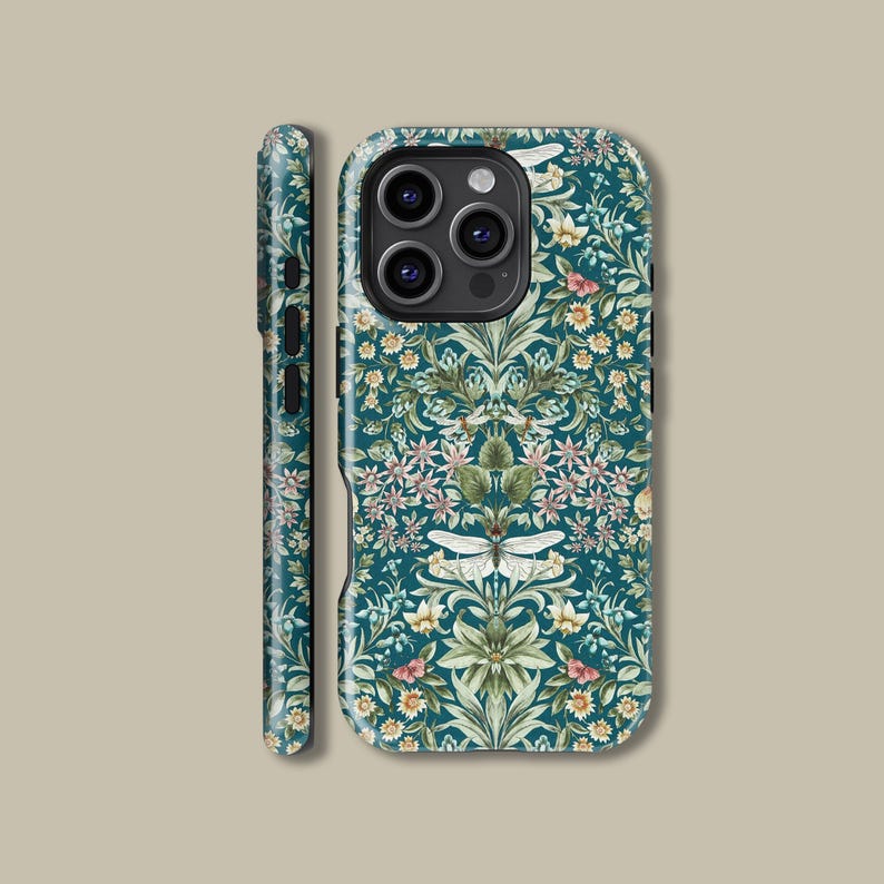 May include: A teal phone case with a floral pattern featuring white, pink, and yellow flowers, and green leaves. The case has a detailed design with a symmetrical arrangement of botanical elements. The side of the case is also visible, showing the same pattern.