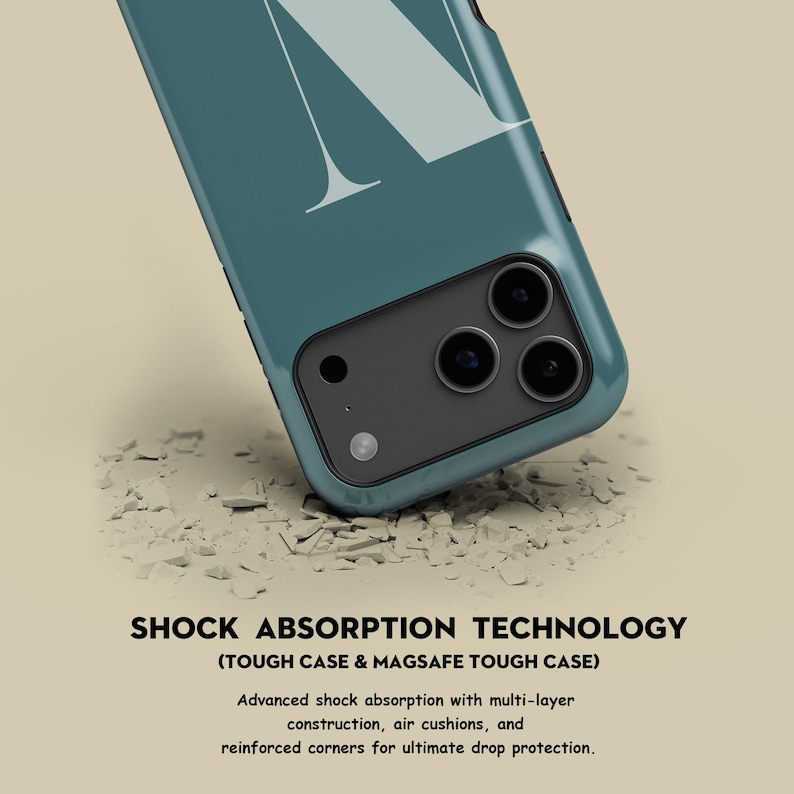 Op de afbeelding: Teal telefoonhoesje met een groot wit letter "N" ontwerp. De hoes heeft een zwarte cameramodule met drie lenzen. De tekst "SHOCK ABSORPTION TECHNOLOGY" is zichtbaar.