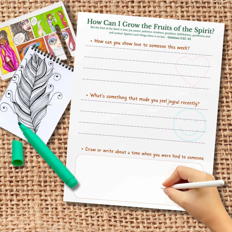 May include: A journal page with the title "How Can I Grow the Fruits of the Spirit?" and prompts for reflection. A green marker and a small notepad with a feather drawing are also visible.
