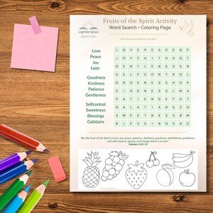 May include: A printed activity sheet titled "Fruits of the Spirit Activity" with a word search and coloring page. The sheet includes a list of words and a grid to find them, along with line drawings of fruits. Colored pencils, an eraser, and a pink sticky note are on a wooden surface.