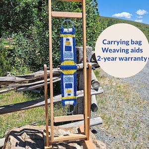 May include: A wooden weaving loom stand featuring a vertical frame with adjustable side supports. A blue, yellow, and white woven strap is suspended within the frame. Text on the image includes Versatile, Carrying bag, Weaving aids, 2-year warranty, and removable stand included.