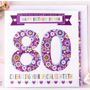 May include: A personalised birthday card for an 80th birthday. The card displays a large "80" in purple with floral patterns, the text "HAPPY BIRTHDAY BRENDA", and "CELEBRATING YOUR SPECIAL EIGHTIETH". The card is on a white background.