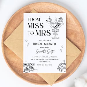 Könnte beinhalten: Eine weiße Einladungskarte mit dem Text "FROM MISS TO MRS" und Details für eine Brautparty, einschließlich des Namens der Geehrten, Datum, Uhrzeit und Ort. Die Karte zeigt Illustrationen einer Frau in einem Martini-Glas, Cocktails und einer Discokugel.