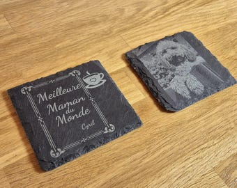 Puede incluir: Dos posavasos de pizarra negra. Un posavasos tiene un diseño de una taza de café con un corazón y el texto "Meilleure Maman du Monde" y el nombre "Cyril". El otro posavasos tiene una foto en blanco y negro de un perro.