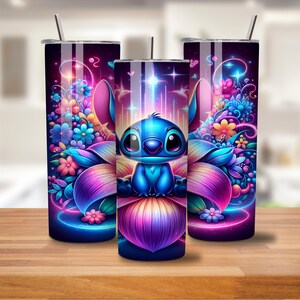 K&ouml;nnte beinhalten: Drei Edelstahlbecher mit einem farbenfrohen Design, das einen blauen Stitch-Charakter aus Lilo & Stitch zeigt, der auf einer Blume sitzt. Der Hintergrund ist dunkelblau mit rosa, lila und gelben Blumen.