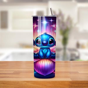 K&ouml;nnte beinhalten: Ein blauer und lilafarbener Edelstahlbecher mit einer Zeichentrickfigur von Stitch aus Lilo & Stitch, die auf einer Blume sitzt. Der Hintergrund ist eine farbenfrohe Galaxie mit Sternen und Schmetterlingen.