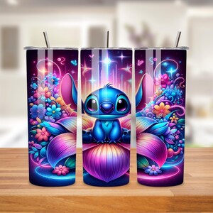 K&ouml;nnte beinhalten: Drei Edelstahlbecher mit einem farbenfrohen Design, das Stitch aus Lilo & Stitch zeigt. Das Design zeigt Stitch, der auf einer Blume mit einem lila, rosa und blauen Farbverlauf sitzt. Der Hintergrund ist dunkelblau mit Sternen und Blumen.