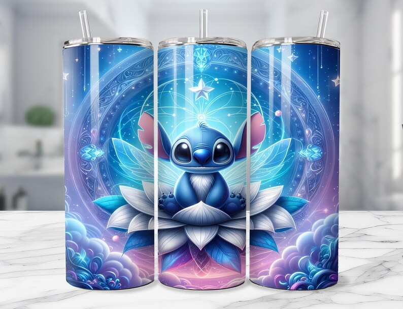 May include: A set of three stainless steel tumblers with a whimsical design. Each tumbler features a blue cartoon character with large eyes, sitting on a white and blue flower, set against a celestial background with stars and clouds. The tumblers have a straw.