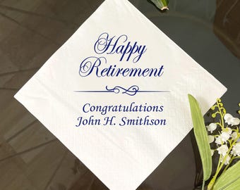 May include: White square napkin with the words "Happy Retirement" in elegant navy blue script. Below, it reads "Congratulations John H. Smithson." A decorative line separates the phrases. The napkin is placed on a dark surface.