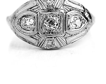 May include: A silver ring with a geometric design and multiple small diamonds.