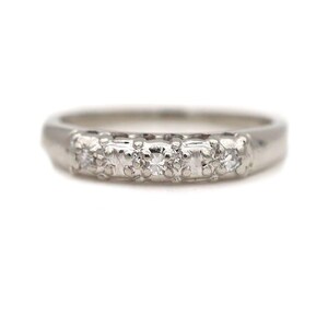 May include: A silver band with five small diamonds set in a row.